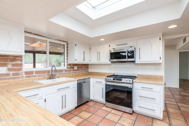 kitchen featuring white cabinetry, appliances with stainless steel finishes, sink, and backsplash