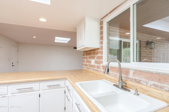 kitchen with white cabinetry and sink