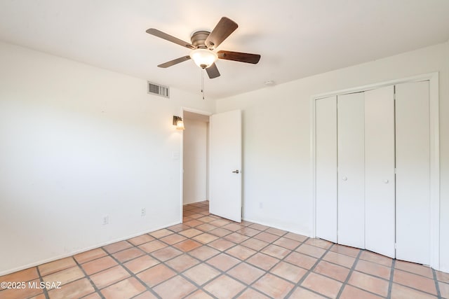 unfurnished bedroom featuring light tile patterned floors, a closet, and ceiling fan