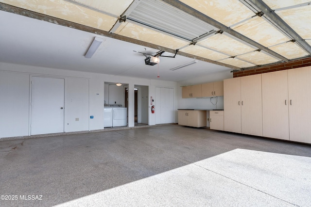 garage with independent washer and dryer and a garage door opener