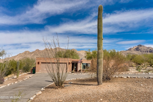 adobe home featuring a garage and a mountain view