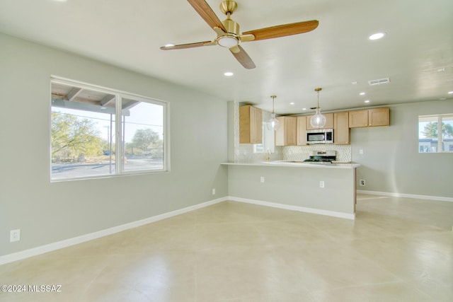 kitchen with light brown cabinets, sink, decorative light fixtures, decorative backsplash, and appliances with stainless steel finishes