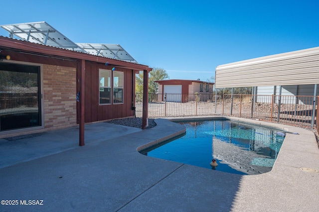 view of swimming pool with an outbuilding, a patio, and a garage