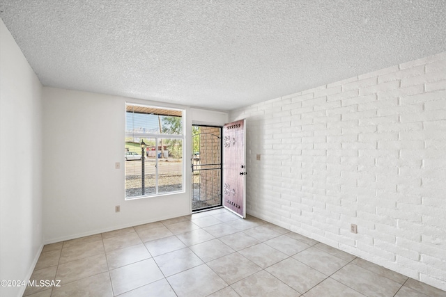 spare room with light tile patterned floors and a textured ceiling