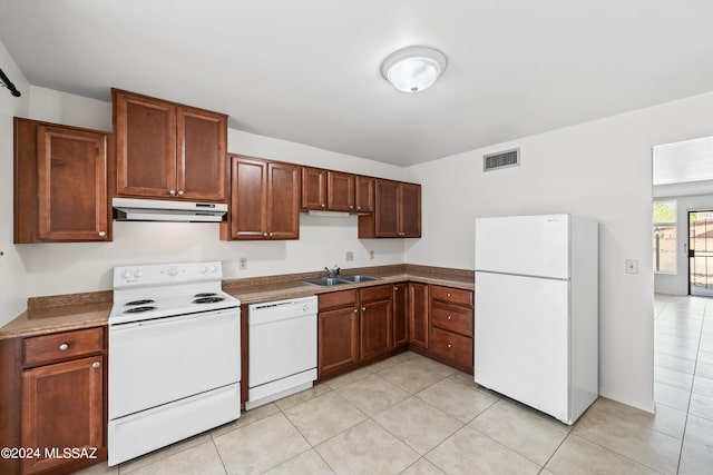 kitchen featuring light tile patterned floors, white appliances, and sink