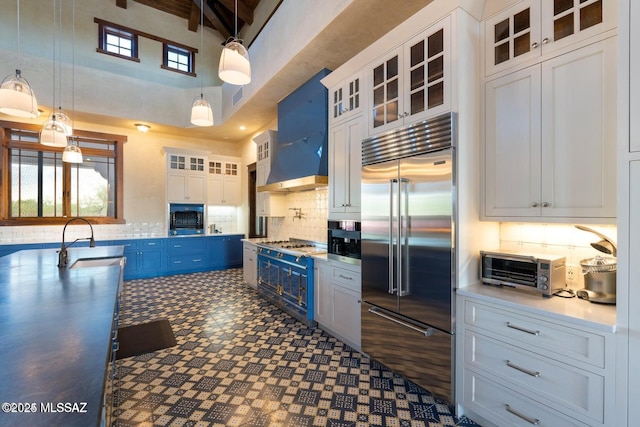 kitchen featuring pendant lighting, sink, blue cabinetry, appliances with stainless steel finishes, and white cabinetry