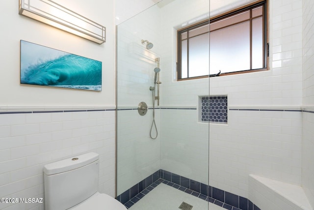 bathroom with toilet, tile walls, and walk in shower