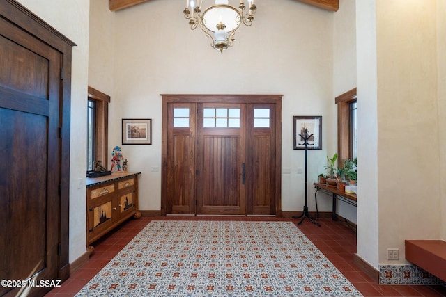 tiled foyer with a chandelier and a high ceiling