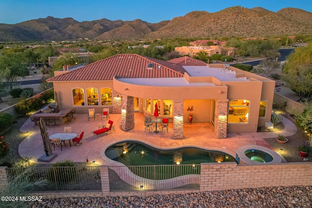 view of swimming pool featuring a patio, an in ground hot tub, and a mountain view