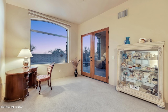 living area featuring french doors and carpet