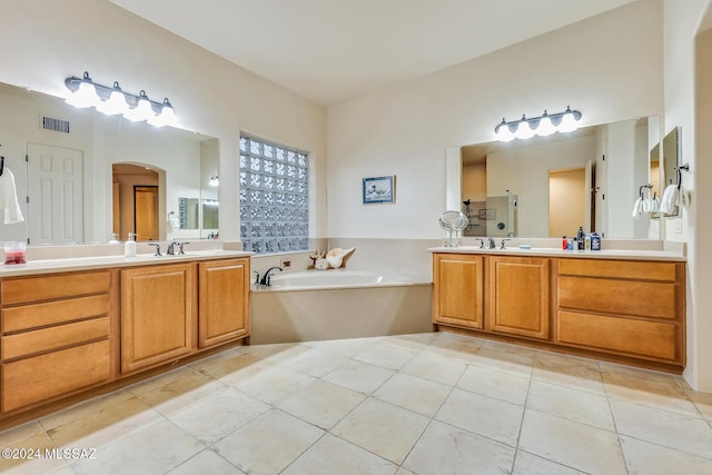 bathroom with a tub, tile patterned floors, and vanity