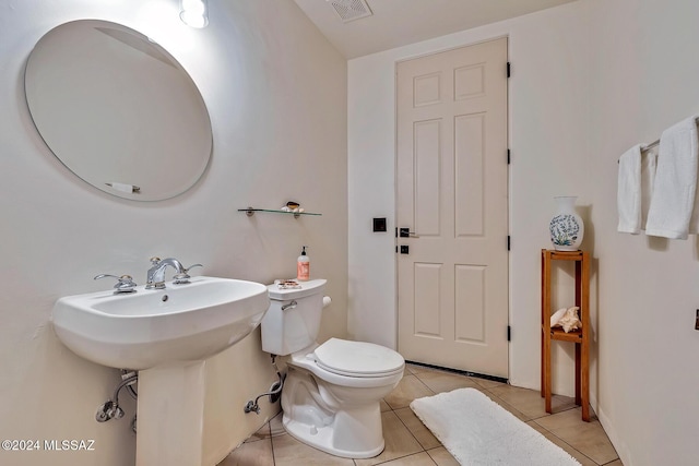 bathroom featuring toilet, tile patterned floors, and sink