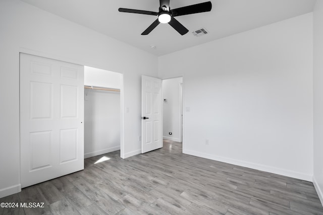 unfurnished bedroom with a closet, light hardwood / wood-style flooring, and ceiling fan