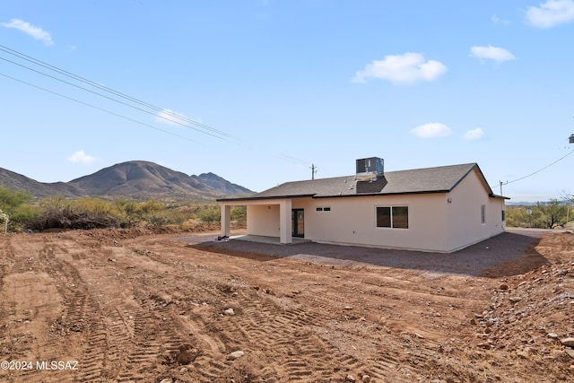 rear view of property featuring a mountain view, cooling unit, and a patio area