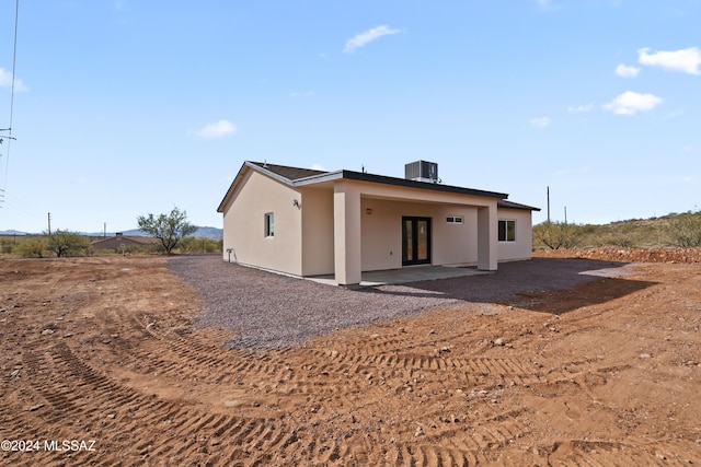 rear view of property with central air condition unit and a patio