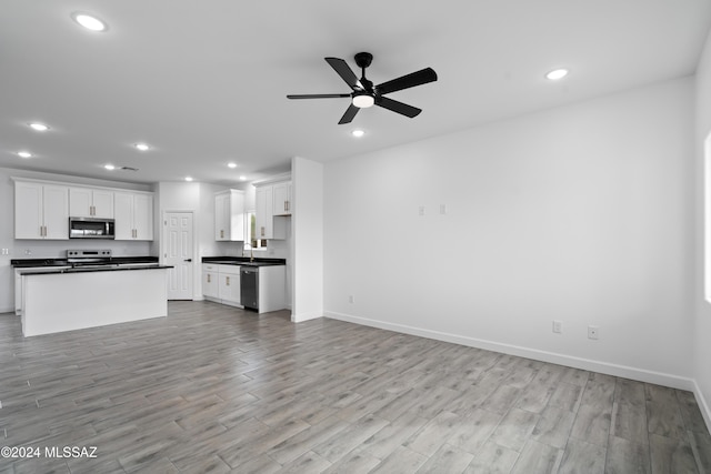 unfurnished living room with light hardwood / wood-style flooring and ceiling fan