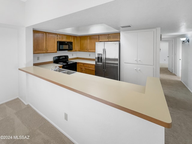 kitchen with black appliances, sink, kitchen peninsula, and light carpet