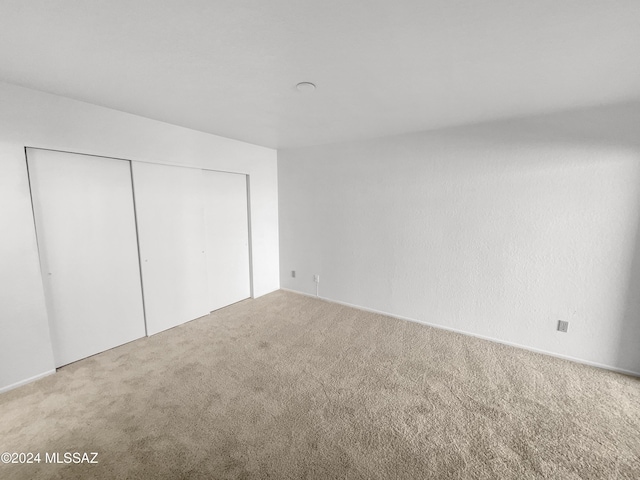 unfurnished bedroom with carpet flooring and a closet