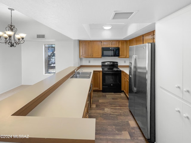 kitchen featuring black appliances, a raised ceiling, sink, hanging light fixtures, and kitchen peninsula