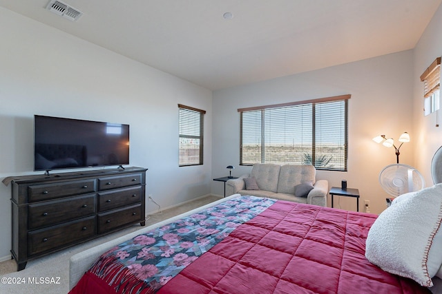 carpeted bedroom featuring multiple windows