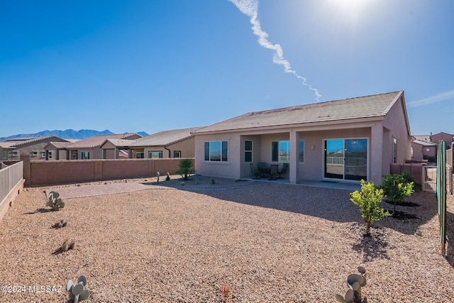 back of house with a mountain view and a patio