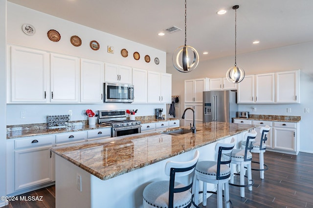 kitchen featuring white cabinetry, a center island with sink, stainless steel appliances, and sink