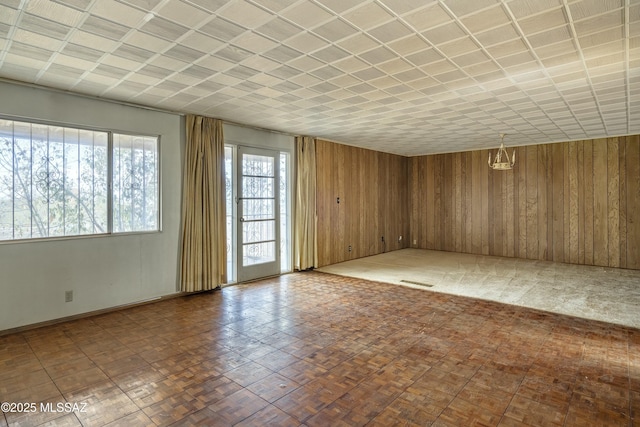 spare room with visible vents and wooden walls