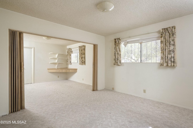 carpeted empty room featuring a textured ceiling