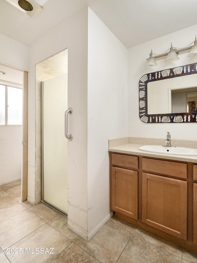 full bathroom with baseboards, a stall shower, and vanity