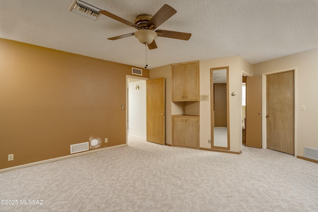 unfurnished bedroom with visible vents, a textured ceiling, and carpet floors