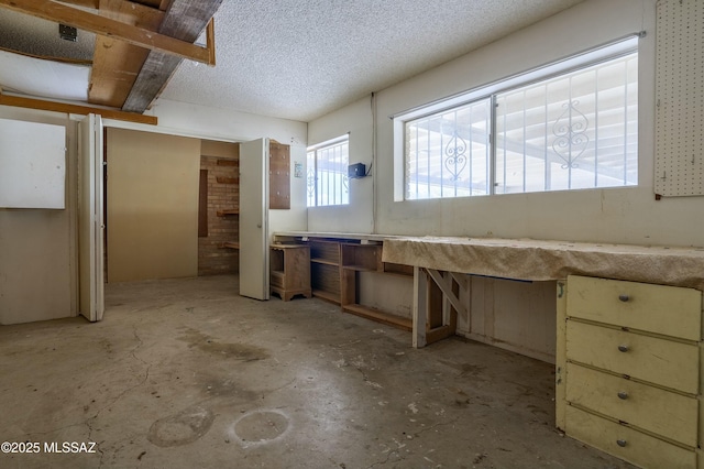 misc room with a textured ceiling and unfinished concrete floors