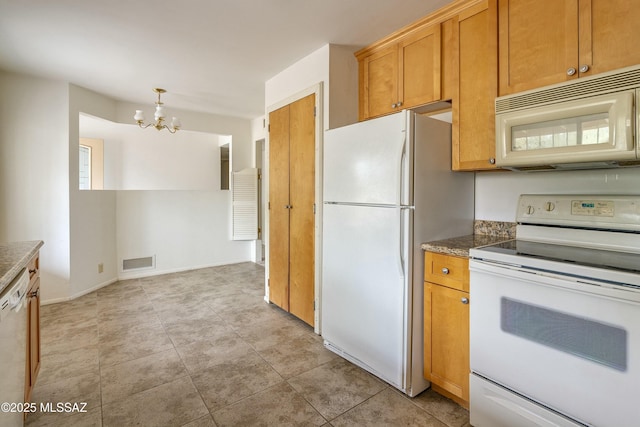 kitchen featuring white appliances, a notable chandelier, brown cabinetry, and visible vents