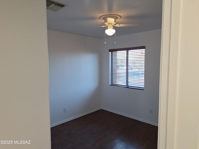 spare room featuring ceiling fan and dark wood-type flooring