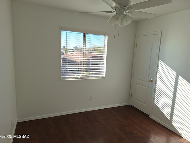 empty room with ceiling fan and dark wood-type flooring