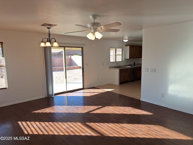 spare room with ceiling fan with notable chandelier, light hardwood / wood-style floors, and sink