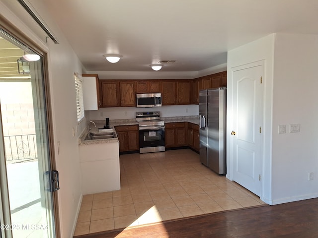 kitchen featuring sink, light tile patterned floors, and stainless steel appliances