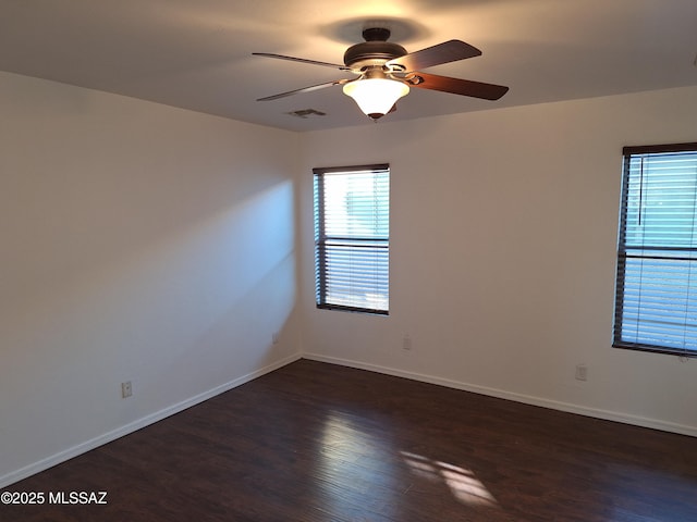 empty room featuring dark hardwood / wood-style flooring and ceiling fan