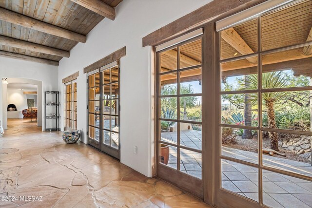 doorway to outside featuring french doors, lofted ceiling with beams, a wealth of natural light, and wooden ceiling