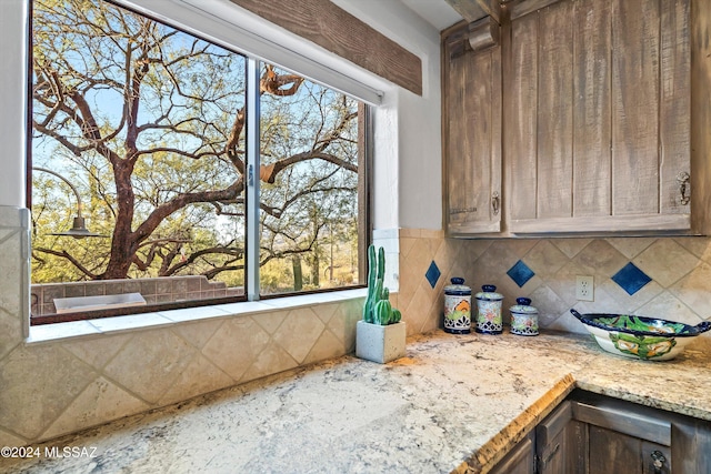 kitchen featuring decorative backsplash and light stone counters