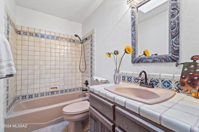 full bathroom with toilet, vanity, and tiled shower / bath