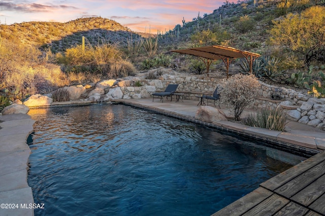 pool at dusk with a mountain view and a patio