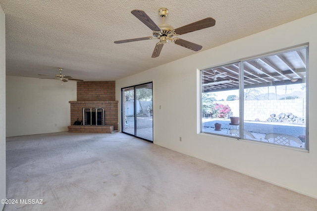 unfurnished living room with a fireplace, a ceiling fan, a textured ceiling, and light colored carpet