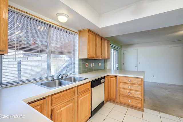 kitchen with a peninsula, a sink, light countertops, backsplash, and dishwasher