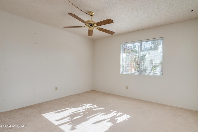 unfurnished room featuring a textured ceiling, ceiling fan, and light colored carpet