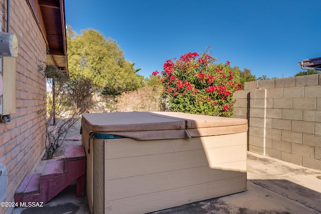 details with a hot tub and fence