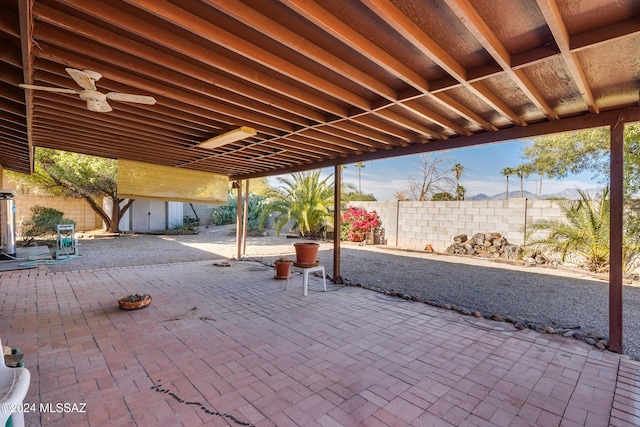 view of patio with a ceiling fan, a fenced backyard, an outdoor structure, and a storage shed