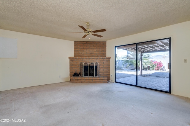 unfurnished living room featuring a ceiling fan, light carpet, a fireplace, and a textured ceiling