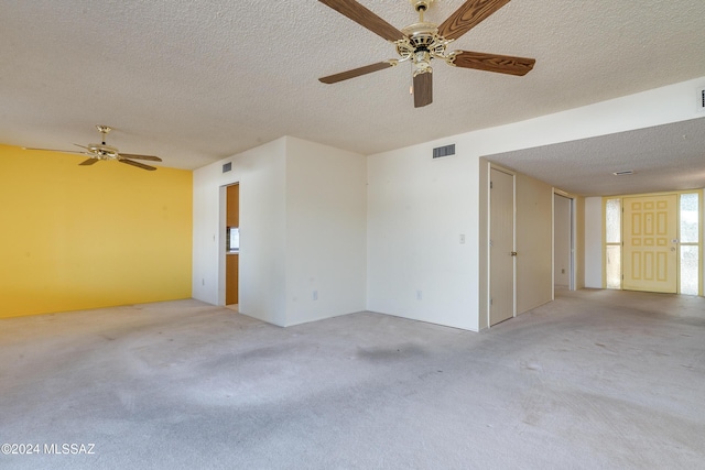 empty room featuring light colored carpet, visible vents, and a textured ceiling