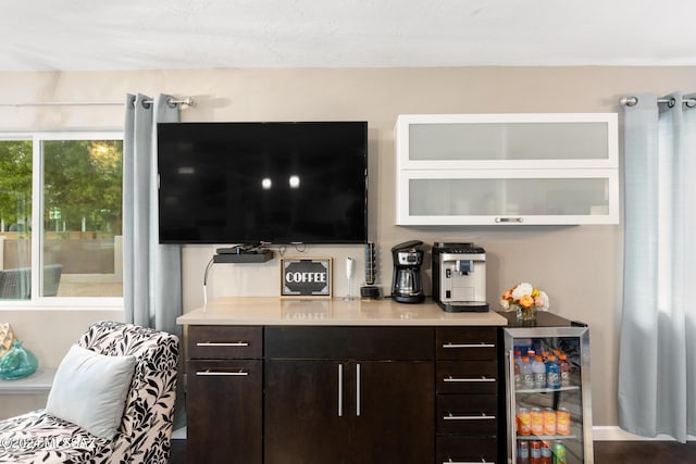 bar with dark brown cabinets and wine cooler