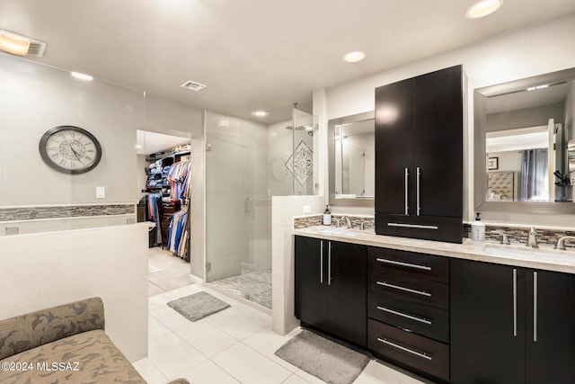 bathroom with a shower with shower door, tile walls, tile patterned floors, and vanity